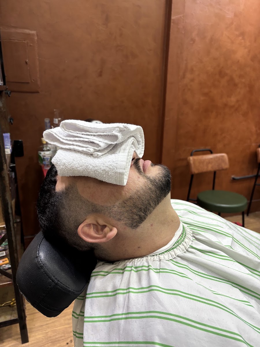 Cliente com toalha quente no rosto durante a barba